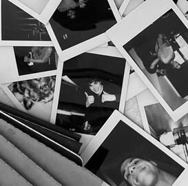 a pile of polaroids laid out of the scream vi/6 cast, main one in the center being jack champion as ethan landry holding two thumbs up.